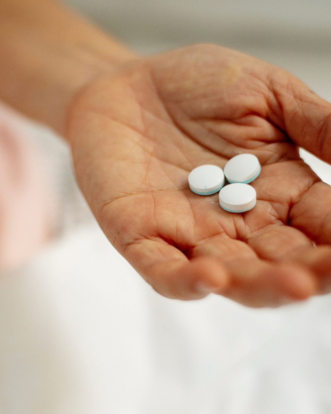 Frau hält Antibiotika-Pillen in der Hand